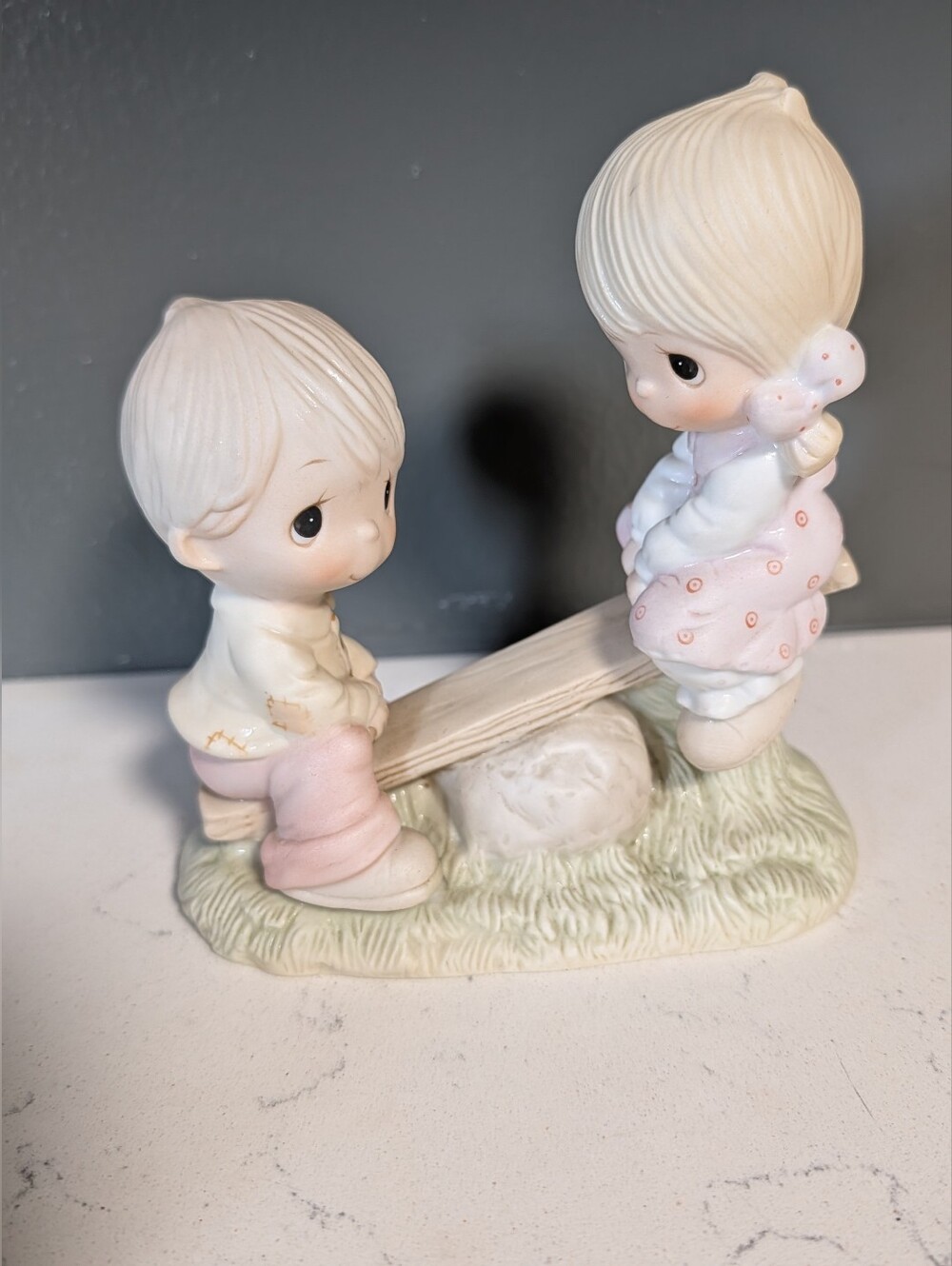 Vintage 1977 Precious Moments figurine of a boy & a girl on a seesaw.